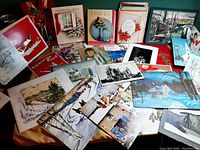 Photo showing a variety of vintage holiday cards with Christmas and winter artwork including snow-covered scenes and wreaths.