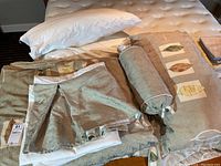 Full view of the duvet cover with leaf pattern, bolster pillow, and pillows on a mattress.