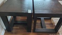 Top view of two square wooden side tables showing dark stained wood grain and heavy, sturdy construction.