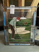Front view of stained glass panel showing golfing figure and golf course scene with sand trap entry and flag.