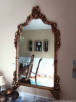 Full view of mirror hung on wall showing reflection and hanging hardware
