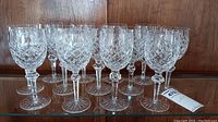 Thirteen glasses arranged in three rows on wooden surface