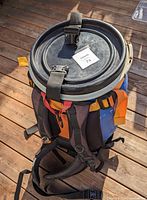 Top view of blue camping barrel showing locking airtight lid with black straps and tag attached