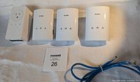 Four D-Link Powerline Ethernet Adapters arranged horizontally: three DHP-306AV models and one DHP-P338AV model with a passthrough power outlet; also included is one blue Ethernet cable.