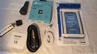 Full view of lot items including TP-Link Bluetooth adapter box, cables, car charger, and waterproof pouch.