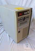 Front and side view of beige vintage desktop computer tower with numeric LED display and floppy drives.