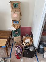 Overall view showing stacked decorative kit boxes, a bag of embroidery hoops and fabric supplies