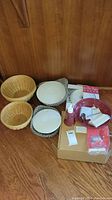 Overview of all items including baskets, liners, pie plates, soap dispenser, and boxed accessories.