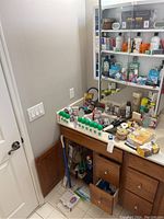 Bathroom vanity with multiple personal care products including deodorant sticks, cream bleach, and curling irons.