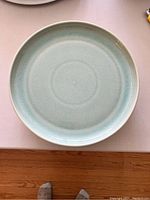 Top view of a single turquoise crackle glaze dinner plate showing the color and texture.