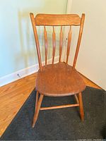 Full frontal view of the antique arrow back pine chair showing seat, backrest with four spindles and legs.