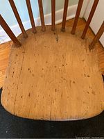 Close-up of the wooden seat showing natural wear and wood grain details.