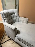 Side angle view showing the button tufted backrest and armrest with velvet fabric and some wear marks