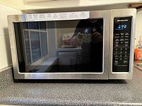 Front view of the KitchenAid stainless steel microwave convection oven showing the large door with viewing window and the control panel with digital display and buttons.