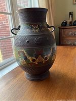 Full view of Japanese brass champleve vase showing shape, enamel decoration and ring handles on sides.