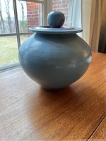 Side view of the blue metallic raku vase showing its shape and surface finish.