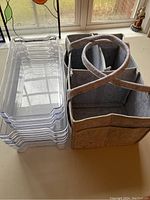Photo showing collapsing fabric diaper caddy with handle and compartments alongside clear plastic storage bins.