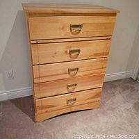 Front view of the solid wood 5 drawer tallboy dresser showing brass tone cup handles and natural wood grain.