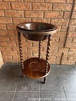 Wooden barley twist stand holding a brown enamel basin, showing overall design and structure.