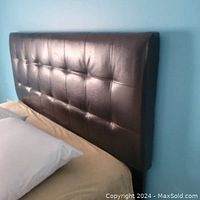 Side angle view showing tufted pattern and top edge detail of the headboard attached to the bed.