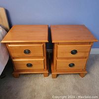 Pair of solid maple nightstands placed side by side showing full frontal view and top surfaces.