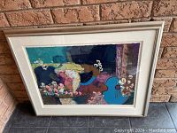 Framed serigraph artwork leaning against a brick wall, showing overall colors and frame style.