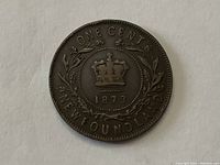 Reverse side showing crown, denomination 'ONE CENT', 'NEWFOUNDLAND' and date '1873' surrounded by laurel wreath.
