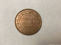 Front side of 1882 Canadian Large Penny coin showing "ONE CENT 1882" surrounded by maple leaf wreath design.