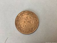 Reverse side of 1910 Canadian Large Penny showing denomination and date surrounded by maple leaves.