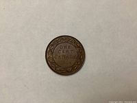 Reverse side of 1914 Canadian large penny one cent coin showing denomination and date within a decorative vine border.