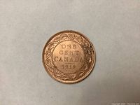 Reverse side of 1919 Canadian Large Penny with 'ONE CENT CANADA 1919' in center and wreath surrounding text.