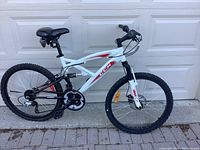 Full side view of the entire bicycle against a garage door