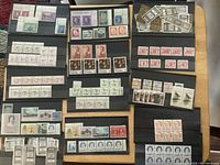 Photo showing entire collection of unused Canadian stamps arranged on black stock pages with a mix of various denominations and designs.