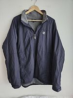 Front view of navy blue BMW jacket with zip closure and fleece lining inside collar and body.