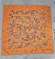 Full view of the large orange silk scarf with dragonfly and floral print.