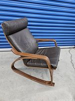 Side view showing bentwood rocker frame and padded leather seat with headrest