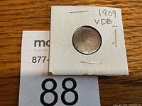 Obverse side of the 1909 VDB Lincoln Wheat Penny in white cardboard 2x2 holder with inscription '1909 VDB'.