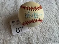 Baseball showing Bob Horner signature and #5 inscription on white surface with red stitching.