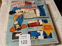 Photo of the front of the box showing colorful Mickey Mouse artwork, set pieces in original styrofoam, and noticeable box damage.