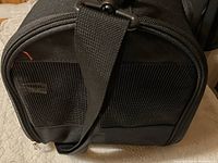 Front view showing mesh ventilation and attached adjustable shoulder strap.