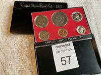 United States Proof Set 1976 coins in original casing with outer black sleeve. Shows all six coins visibly in red foam insert with clear protective cover.