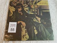 Front cover of Rod Stewart's 'Never A Dull Moment' vinyl album showing artist seated in an armchair in a moody, vintage style with Mercury Records logo.