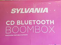 Close-up photo of the purple box with 'Sylvania CD Bluetooth Boombox' printed on it.