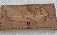 Top view image of the exterior box packaging showing a vintage map design and label 'Canada Millennium 1999'