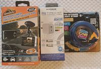 Photo showing the Armor All dashboard camera box, Xtreme PD Type-C charger kit box, and Car Vibez light strip packaging showing slight packaging wear.