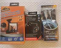All three items side-by-side showing packaging: ArmorAll dash camera, Monster FM transmitter/car charger, and Vistatech Type-C cable.