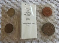 Complete coin set presented in a plastic sleeve with paper insert showing "First Coinage of SOUTH ARABIA 1964 Complete Mint Set" and four coins arranged around it.