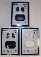 Front view of three Fisher Rival Sound true wireless Bluetooth ear pods sets in packaging: black with black case, black with blue case, and white with white case. Packaging shows storage wear.