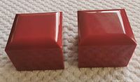 Two red, square James Allen ring boxes closed, showing exterior appearance.