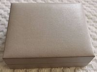 Closed light gray textured jewelry box.